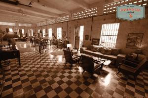 a large room with couches and tables and chairs at Privada Lodge - Historic Hotel in Kratie