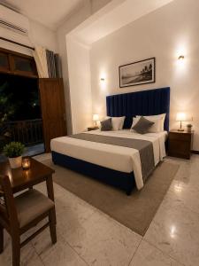 a bedroom with a large bed with a blue headboard at Danketiya Palace in Ahangama +21 photos