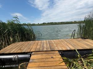 a wooden dock sitting on the side of a lake at Міні-готель На Росі in Steblëv