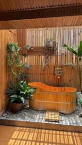 a wooden bathroom with a tub and some plants at Vanilla Homestay Da Lat in Da Lat