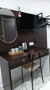a wooden desk with a mirror and a chair at Dwan Hotel in Kota Bharu