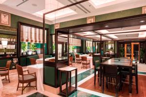 a restaurant with green walls and tables and chairs at Rome Marriott Grand Hotel Flora in Rome