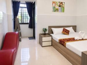 a bedroom with two beds and a red chair at Viora Hotel in Ấp Phước Thiện +4 photos