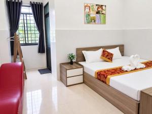 a bedroom with two beds and a red chair at Viora Hotel in Ấp Phước Thiện