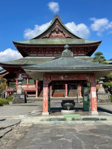 a pagoda building with a fountain in front of it at 天然温泉付 一棟貸し最大12名 近隣施設事前予約で バーベキュー 花火 和羽灯屋 ナウヒヤ in Fuefuki
