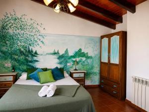 a bedroom with a bed with a painting on the wall at Refugio La Presa in Chulilla