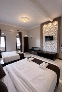 a hotel room with two beds and a television at Parama Bromo Hotel in Ngadisari