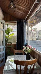 a table with a vase of flowers on a balcony at Vanilla Homestay Da Lat in Da Lat