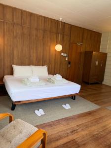 a large bed in a room with slippers on the floor at The Lewis House in San Juan