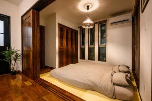 a bedroom with a bed and a chandelier at The Villa Miyako in Hirara