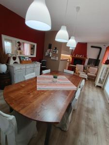 a dining room with a wooden table and white chairs at C & C in Valdobbiadene