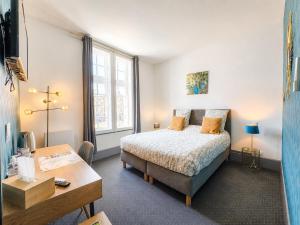 a bedroom with a bed and a table and a desk at La cour des grands in Arras
