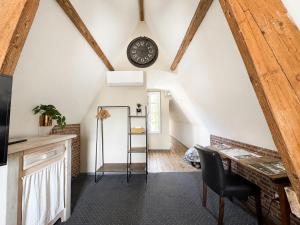 a room with a table and a clock on the wall at La cour des grands in Arras