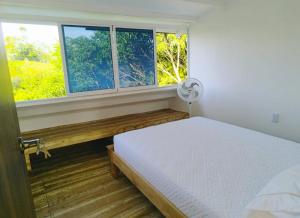 a bedroom with a bed and two windows at Posada Campestre en Doradal in Puerto Triunfo