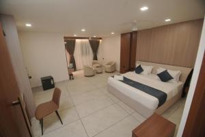 a large bedroom with a large bed and a chair at Empire Suites in Erāttupetta +67 photos