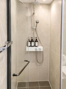 a shower with two bottles on a shelf in a bathroom at Crystal Ocean House 무료주차 in Kwangan-dong +16 photos