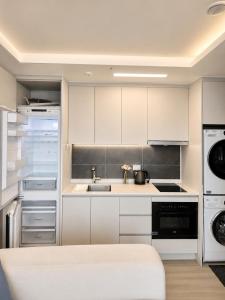 a kitchen with white cabinets and a sink at Crystal Ocean House 무료주차 in Kwangan-dong