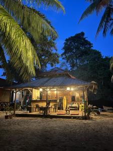 a house with a tent on the beach at night at Maya Sunset Room, Coral Bay Perhentian Island in Perhentian Island