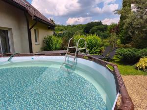 a swimming pool with a swing in a yard at Dom Kowala in Jankowce