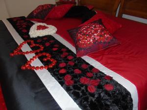 uma cama com rosas vermelhas e uma cruz. em Quintinha dos Queiroses em Vila Boa de Quires