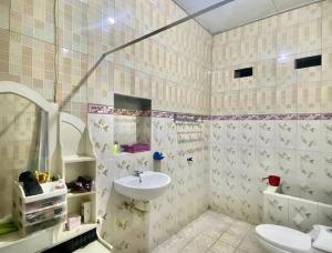 a bathroom with a sink and a toilet at Guest House Brahu Syariah in Trowulan