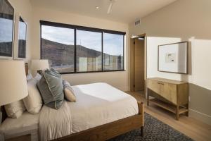 a bedroom with a bed and a large window at LIONSBACK RESORT in Moab +75 photos