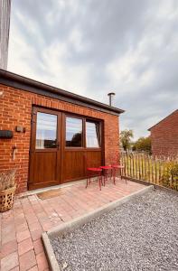 a brick house with two red chairs on a patio at Maison RoHa - B&B & Wellness in Dinant