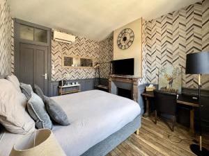 a bedroom with a bed and a desk and a clock at La cour des grands in Arras