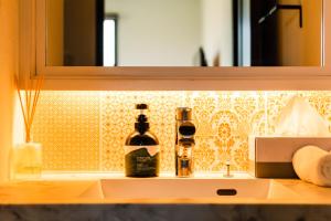 two bottles of wine sitting on a bathroom sink at The Villa Miyako in Hirara +115 photos