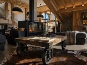 a living room with a table with a fireplace at Chalet Azalée, Montriond, Morzine, Avoriaz in Montriond