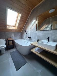 a bathroom with a large tub and a sink at Chalupa u Zíků in Černá v Pošumaví