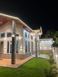 a large house with lights in the yard at night at The Palm Grove Farm Villa in Greater Noida