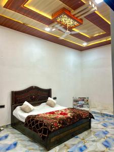 a bedroom with a bed with a coffered ceiling at The Palm Grove Farm Villa in Greater Noida