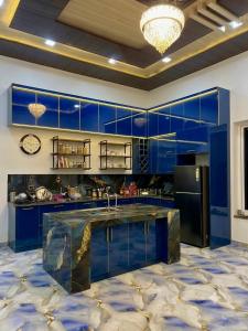 a kitchen with blue cabinets and a marble floor at The Palm Grove Farm Villa in Greater Noida