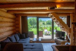 a log cabin living room with a couch and a tv at Cabana de la Stână in Râşnov