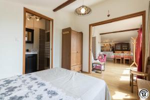 a bedroom with a bed and a living room at Framboisine in Cazères