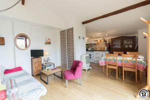 a living room with a couch and a dining room at Framboisine in Cazères