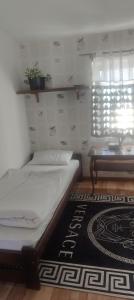 a bedroom with a bed and a table and a rug at Karczma KOSZARKA in Ploski
