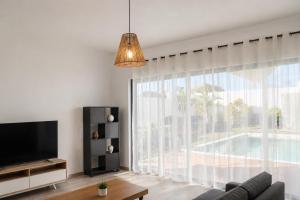 a living room with a tv and a large window at Villa Marea Private Pool in Grand Baie with garden, BBQ & Parking in Grand-Baie