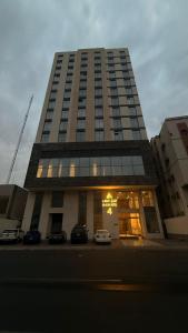 a tall building with cars parked in front of it at فندق العلاء 4 in Al Masfalah