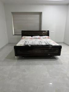a large bed in a room with a white wall at Happy homes in Elūru