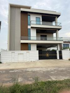a tall building with a fence in front of it at Happy homes in Elūru