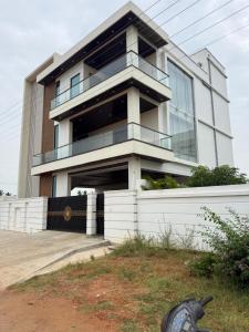 a large white building with a lot of windows at Happy homes in Elūru