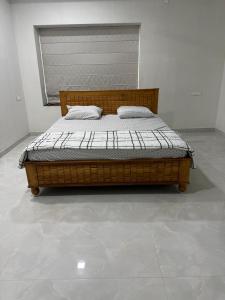 a wooden bed in a white room with at Happy homes in Elūru