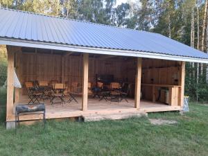 a wooden pavilion with chairs and tables in it at Malowane Wrota Camp - Gniazdko in Łazy +2 photos