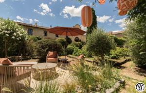 a patio with a table and an umbrella at Le sourire des anges in Saint-Élix-le-Château