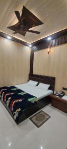 a bedroom with a bed with a ceiling fan at Aashvi Guest House in Ayodhya