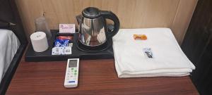 a table with a coffee maker and a remote control at Aashvi Guest House in Ayodhya