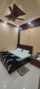 a bedroom with a bed with a ceiling fan at Aashvi Guest House in Ayodhya