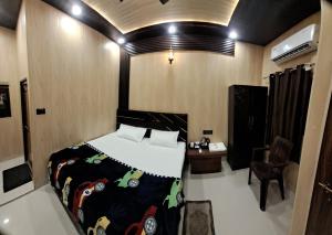 a bedroom with a bed and a desk and a chair at Aashvi Guest House in Ayodhya